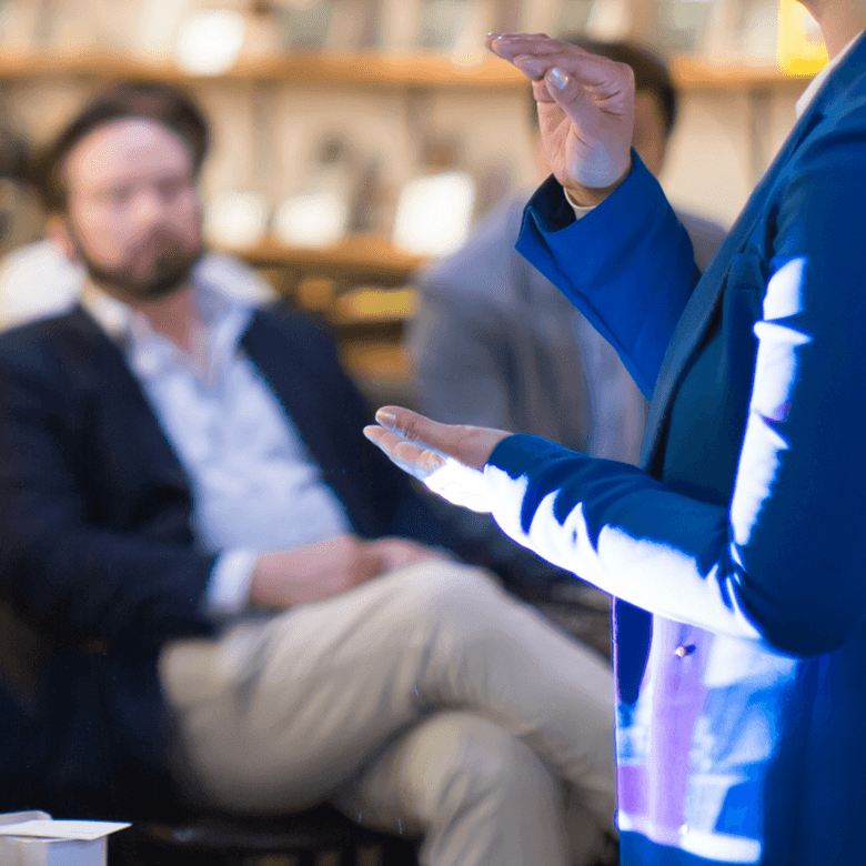 ©Adobstock Right3 Presenter With Hands Held Up During Presentation To Audience. Business Lecture Speaker On Stage. Teacher Speech.